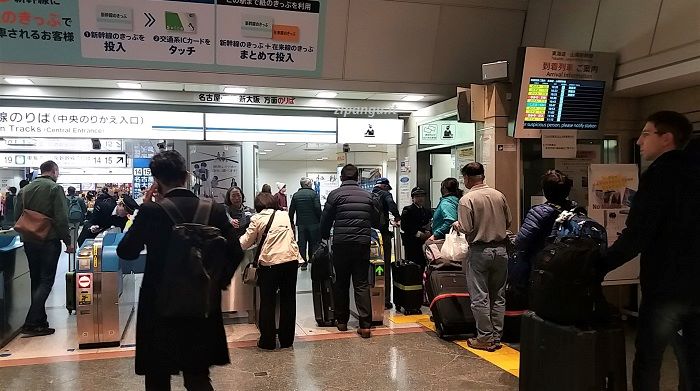 Stazione di Tokyo: passeggeri con bagagli grandi